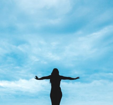 silhouette photography of woman raising her hands